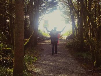 Full length of woman standing on tree trunk in forest