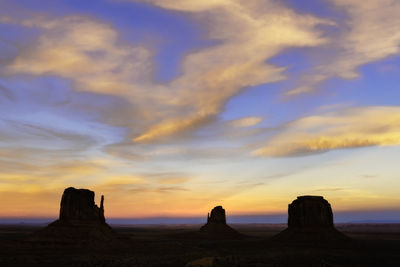 Rock formations on landscape against sky during sunset