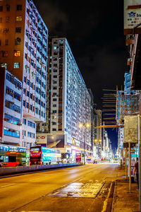 View of city street and buildings at night