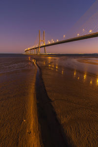 Bridge over sea against clear sky during sunset