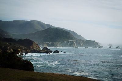 View of calm sea against mountain range