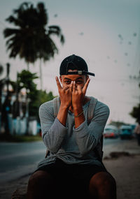 Portrait of young man sitting on beach