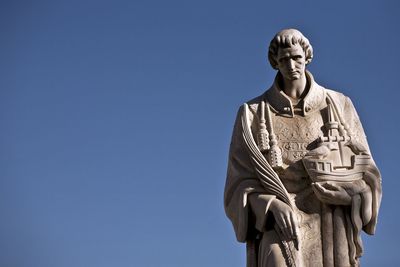 Low angle view of statue against blue sky