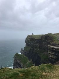 Scenic view of cliff and sea against sky