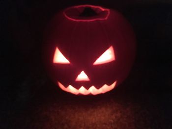 Close-up of illuminated pumpkin against black background