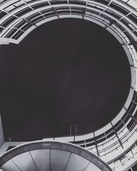 Directly below shot of building against sky at night