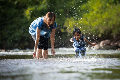 Full length of children playing in water