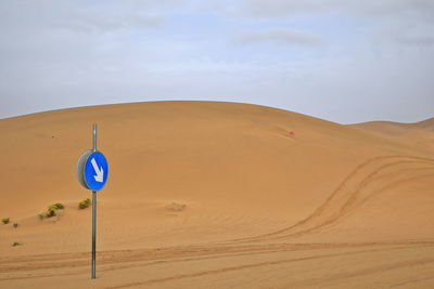 1026 traffic in the desert. mandatory direction sign among the dunes. badain jaran-nei mongol-china.