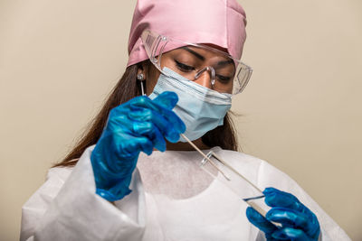 Doctor wearing mask against blue background