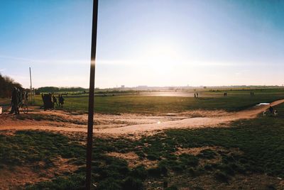 Scenic view of grassy field against sky