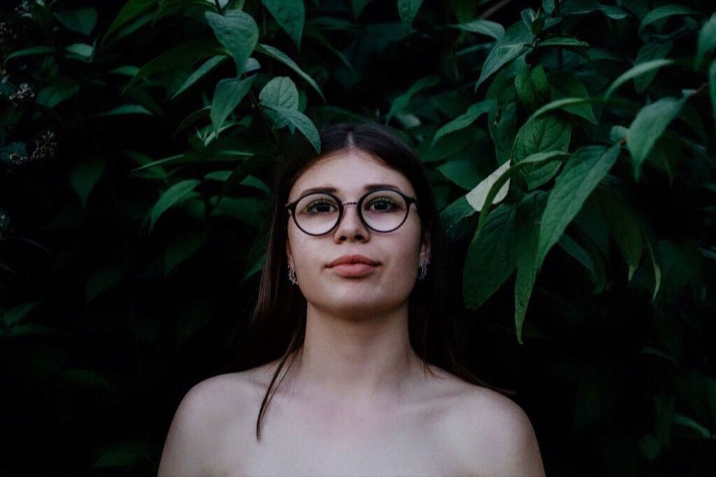 PORTRAIT OF YOUNG WOMAN WITH PLANTS