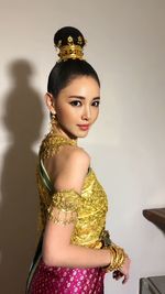 Portrait of young woman standing against white background