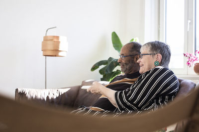 Happy couple watching television in living room