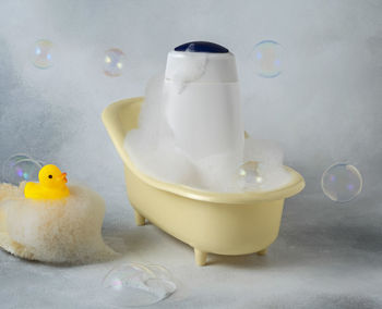 Bathtub with soapy foam and yellow rubber duck