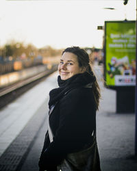 Side view of a smiling young woman looking away