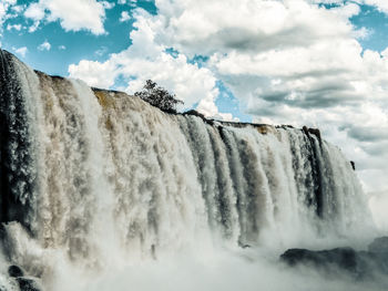 Low angle view of waterfall against sky