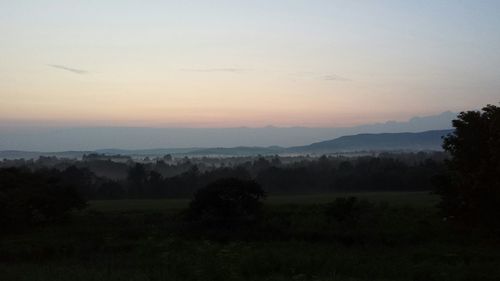 Scenic view of landscape against sky at sunset