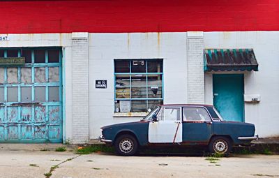 Vintage car parked on street against buildings in city