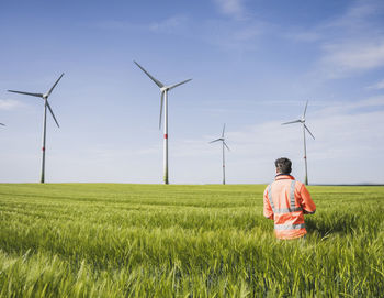 Engineer standing amidst wheat crops on sunny day