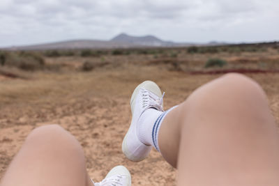 Low section of woman relaxing on sand