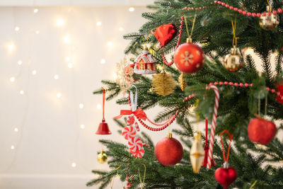 Christmas tree decorated with golden and red toys with bokeh background