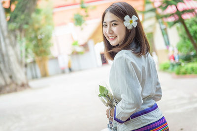 Portrait of smiling young woman standing outdoors