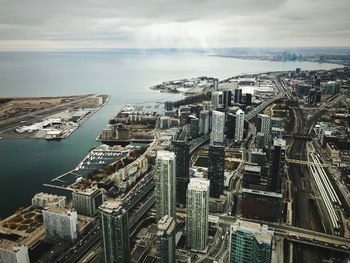 High angle view of buildings by sea against sky