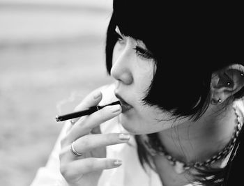 Close-up portrait of woman smoking cigarette