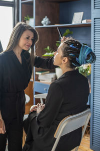 Side view of young woman sitting on table