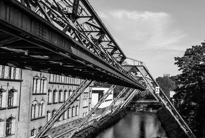 Low angle view of bridge over river against sky