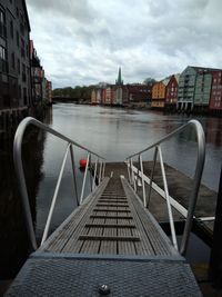 Bridge over river in city against sky