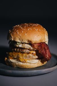 Close-up of burger in plate against black background