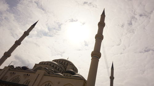 Low angle view of cross in building against sky