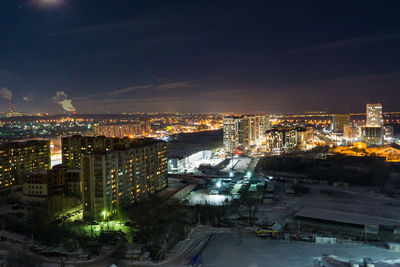 High angle view of illuminated buildings against sky at night