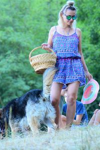 Full length of woman holding basket at park