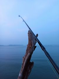 Close-up of driftwood on sea against clear sky