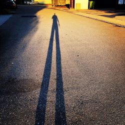 Shadow of man on road