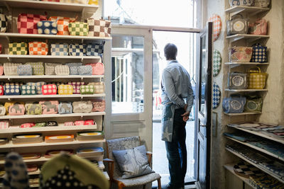 Male owner standing on entrance of fabric shop