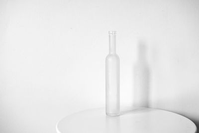 Close-up of empty glass bottle against white background