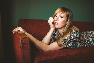 Woman looking away while sitting on sofa