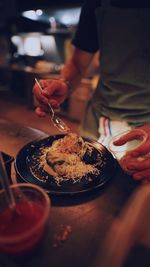 Midsection of man preparing food in restaurant