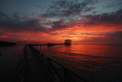 Pier over sea against sky during sunset