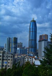 Buildings in city against cloudy sky