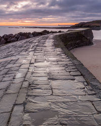 Surface level of sea against sky during sunset