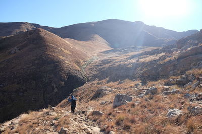  woman walking in scenic view of mountains against sky