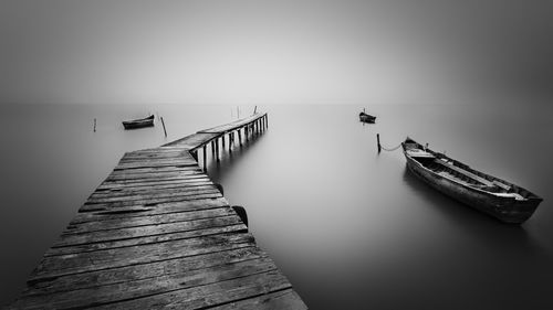 Wooden pier on sea against sky