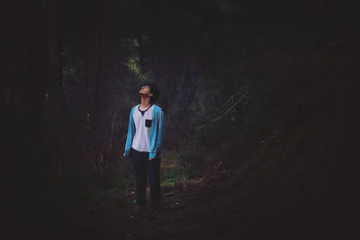 Portrait of young man standing in forest