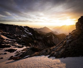 Scenic view of snowcapped mountains against sky during sunset