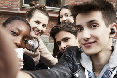 Smiling friends taking selfie in city