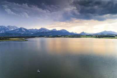 Scenic view of lake by mountains against sky